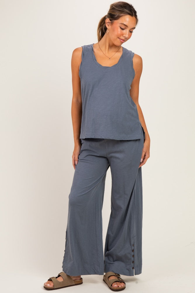 woman wearing a blue sleeveless maternity top and matching wide-leg pants, styled casually with a relaxed fit