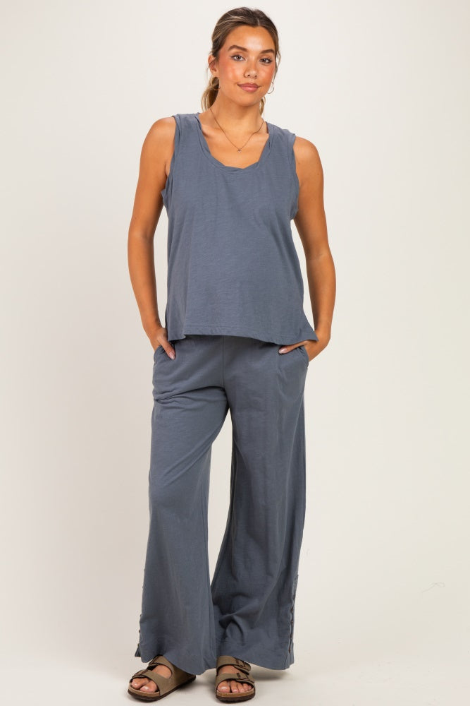woman wearing a blue maternity tank top and wide-leg pants, styled for comfort during pregnancy