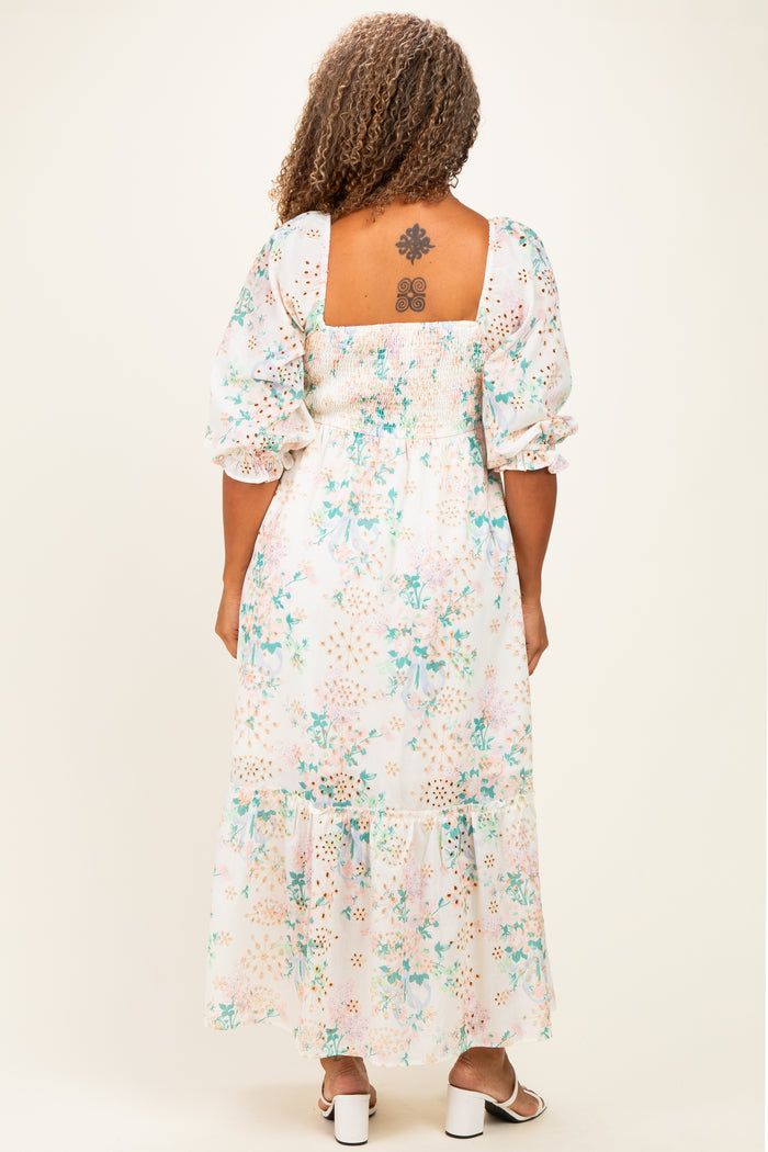 woman wearing a floral print plus size maxi dress with a smocked back and puff sleeves, showing a tattoo on her back