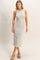 woman wearing a gray and white striped midi tank dress with a fitted silhouette and side slit