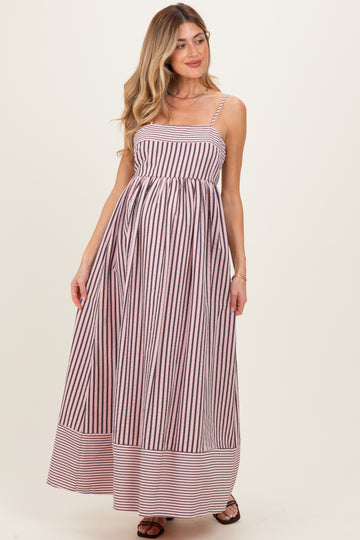 woman wearing a striped maternity maxi dress with spaghetti straps and a flowing skirt, showing her baby bump