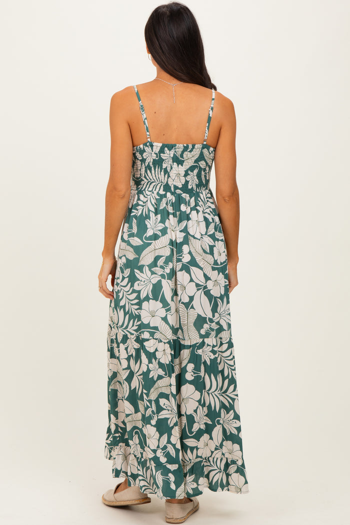 woman wearing a green floral maxi dress with a fitted bodice and tiered skirt, seen from the back