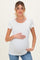 woman wearing a white short sleeve maternity top with scalloped details and holding her baby bump