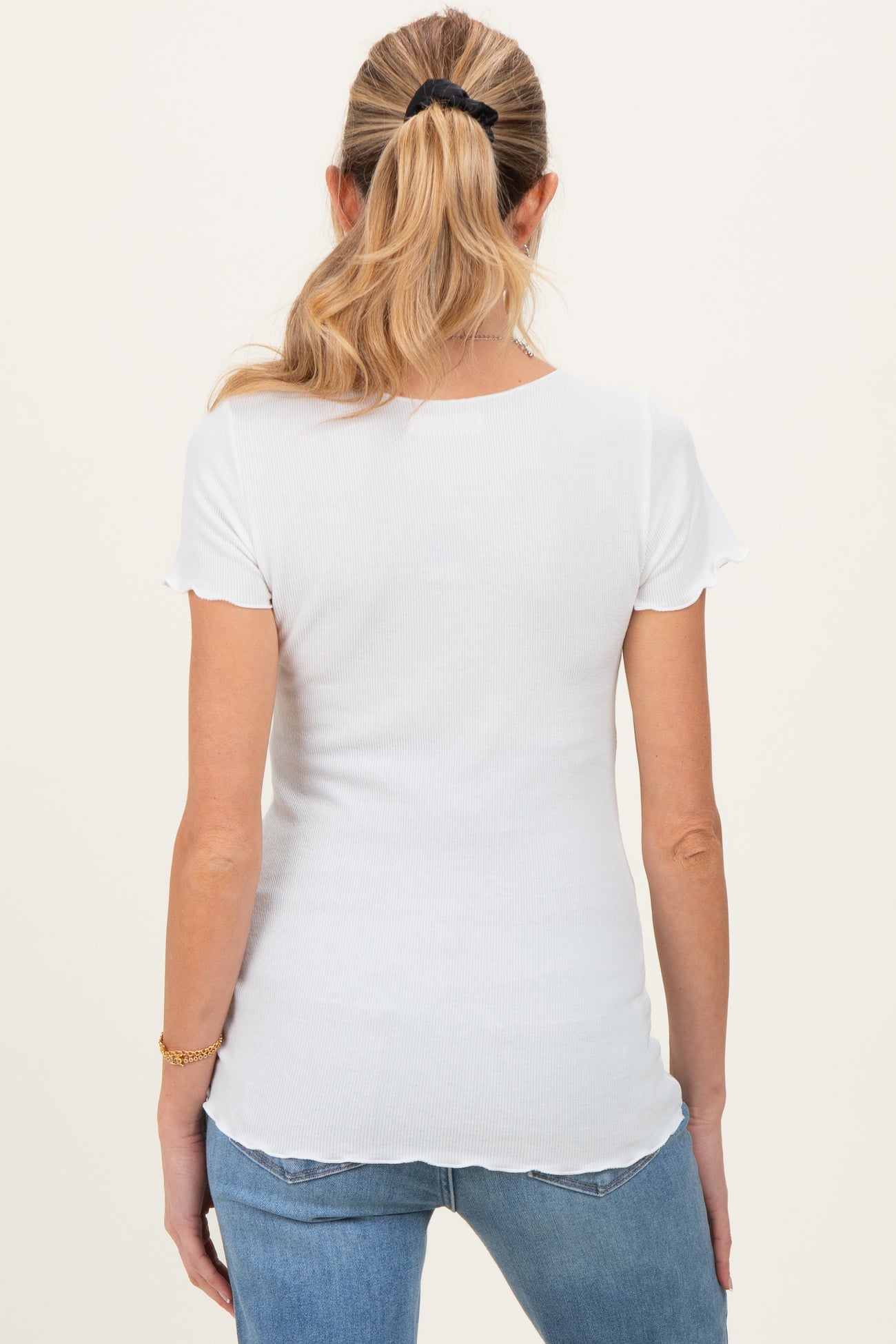 woman wearing a white short sleeve fitted maternity top, view from the back