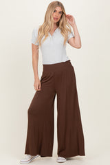 woman wearing a grey short sleeve henley top and brown wide leg pants