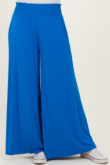 women wearing bright blue wide-leg pants with an elastic waistband and paired with white sneakers