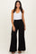 woman wearing a white tank top and black wide-leg pants with a smocked waistband