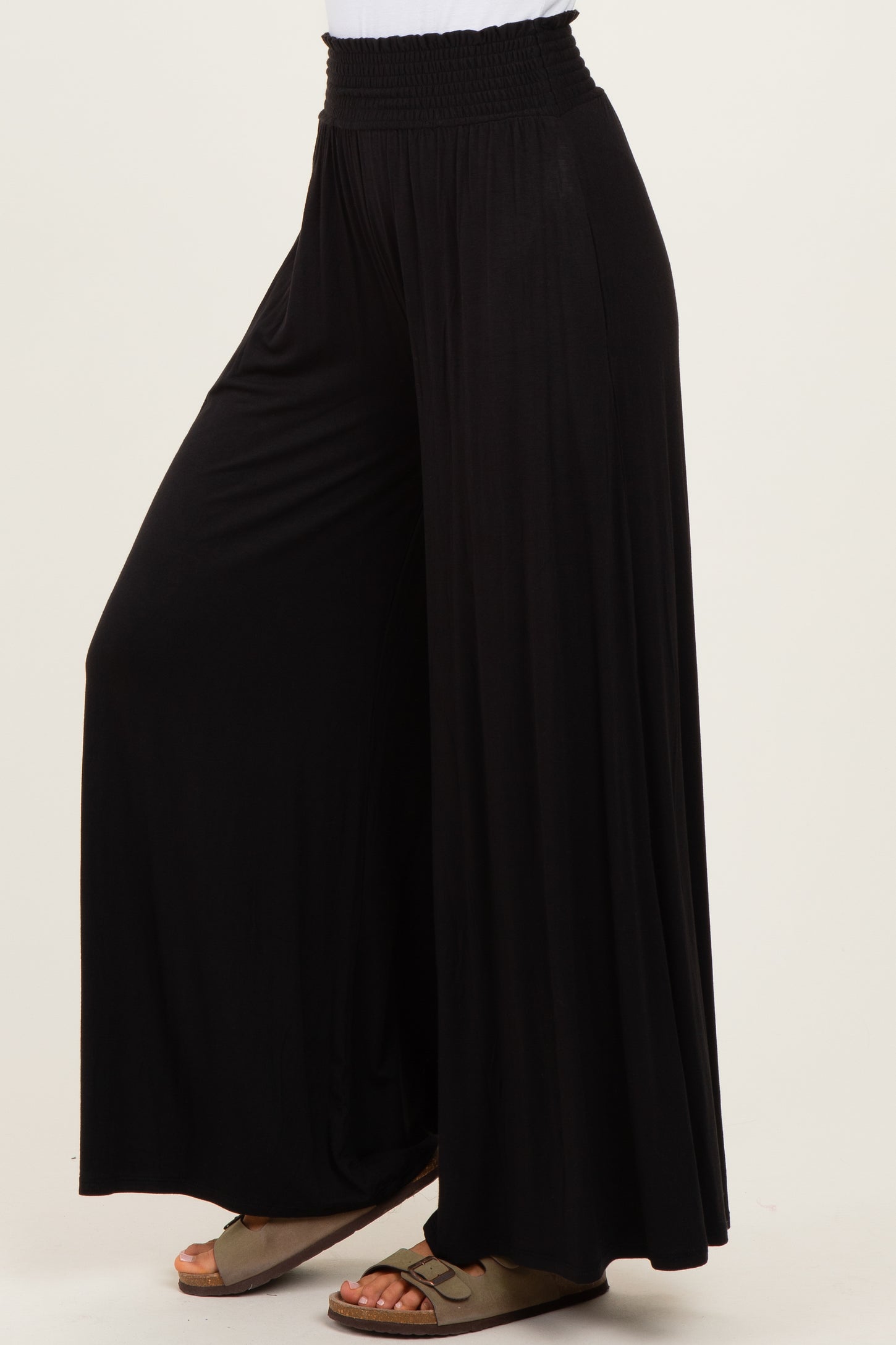 woman wearing black wide-leg pants with an elastic waistband and casual sandals