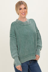 woman wearing a green striped oversized sweater and blue jeans