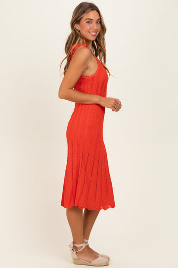 woman wearing a vibrant red knitted midi dress with a flared hem and adjustable straps