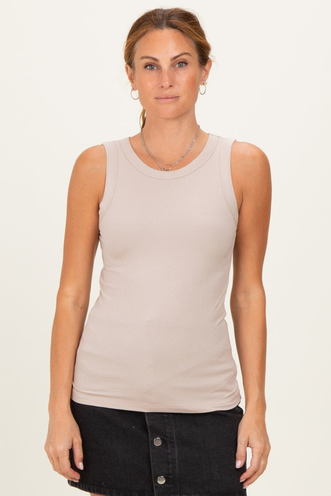 woman wearing a beige ribbed sleeveless top paired with a black denim skirt