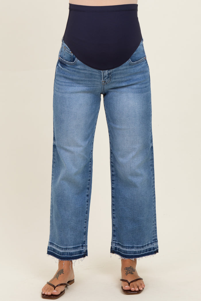maternity wear light wash wide leg jeans with a dark blue over-the-bump waistband, model wearing flip-flops