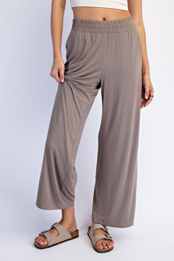 woman wearing light taupe wide-leg pants with an elastic waistband and side ruching, paired with sandals