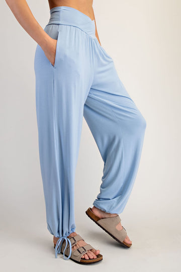 woman wearing light blue wide leg pants with pockets and adjustable drawstring hem, styled with gray sandals