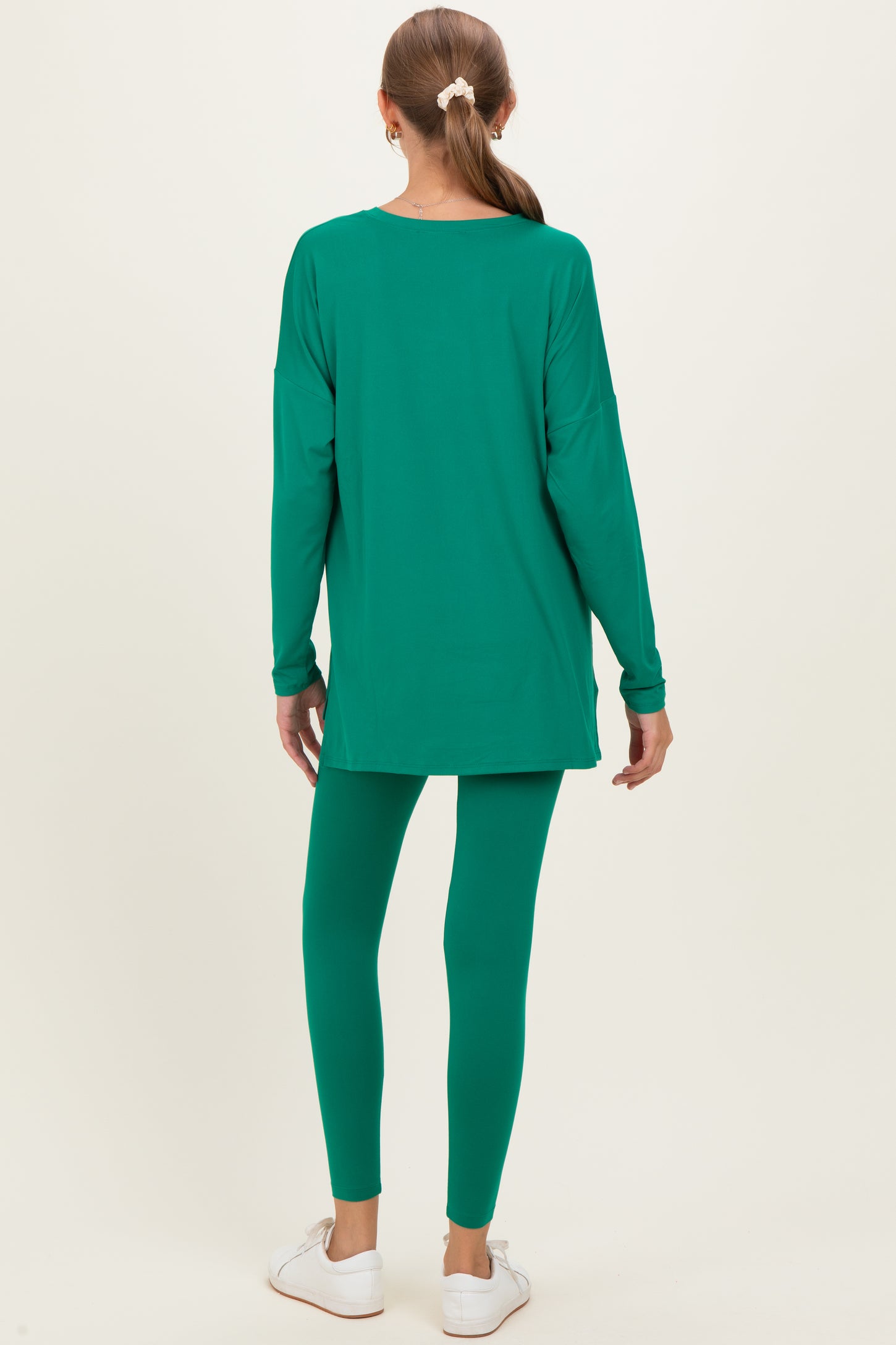 woman wearing a green long sleeve maternity tunic and matching leggings, viewed from the back