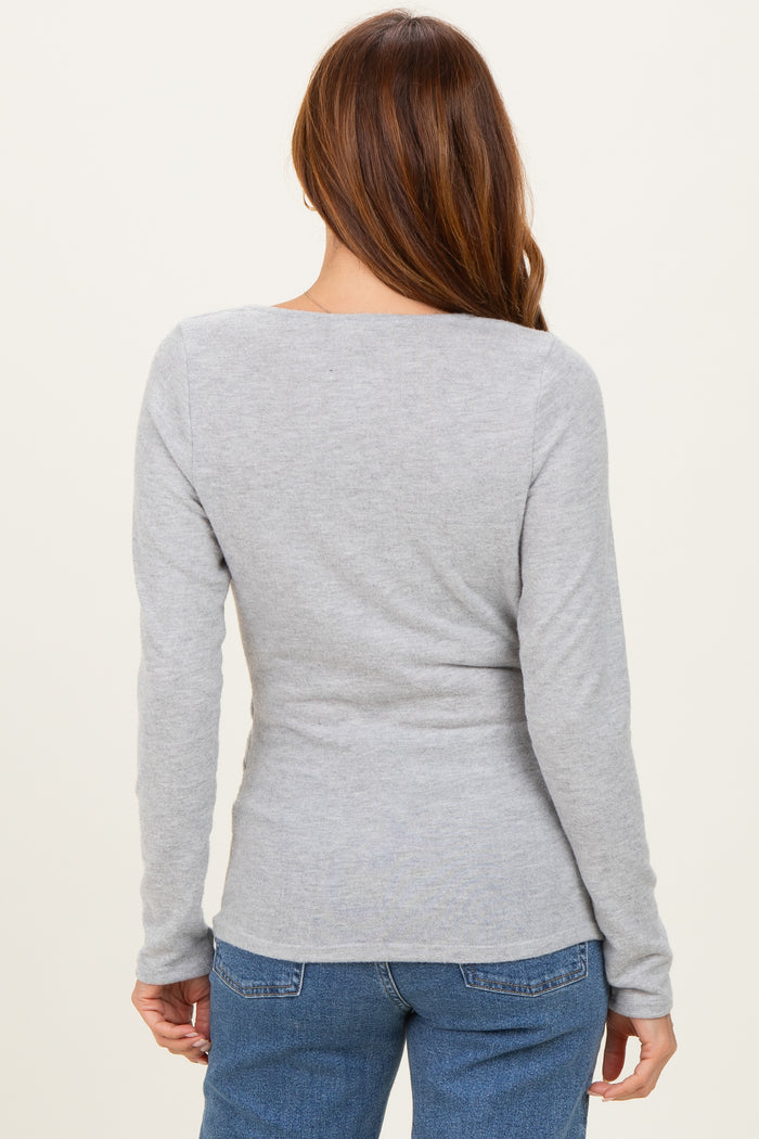 woman wearing a fitted grey long sleeve top, showing the back view with a scoop neckline and soft fabric