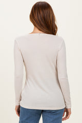 woman wearing a soft beige ribbed long sleeve top seen from the back, paired with blue jeans