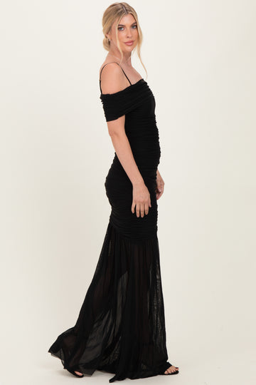 woman wearing a black off-the-shoulder evening gown with ruched detailing and a flowy skirt