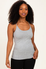 woman wearing a gray spaghettistrap tank top with a fitted style and curly hair