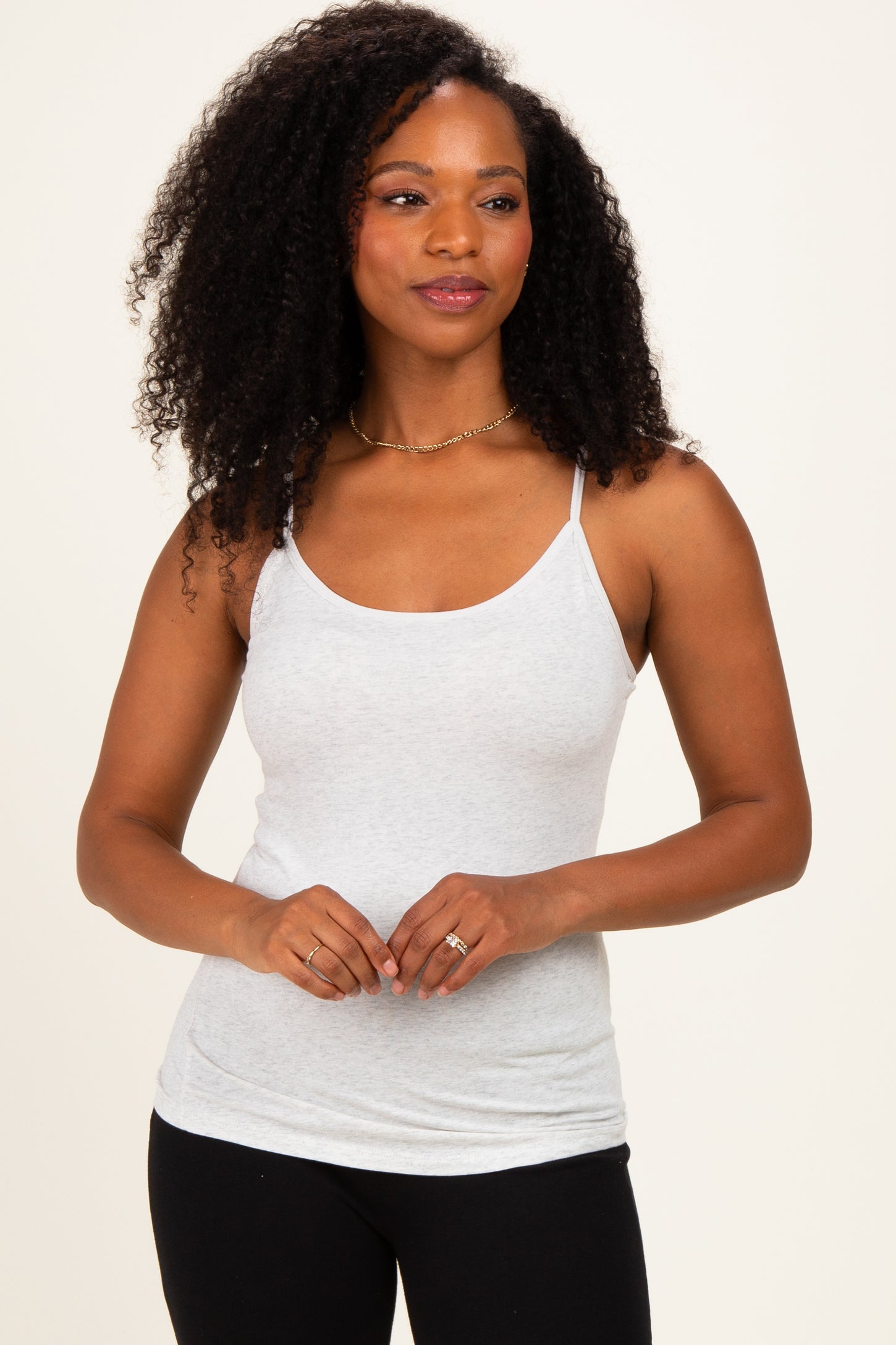 woman wearing a light gray spaghetti strap tank top with a relaxed fit and a scoop neckline