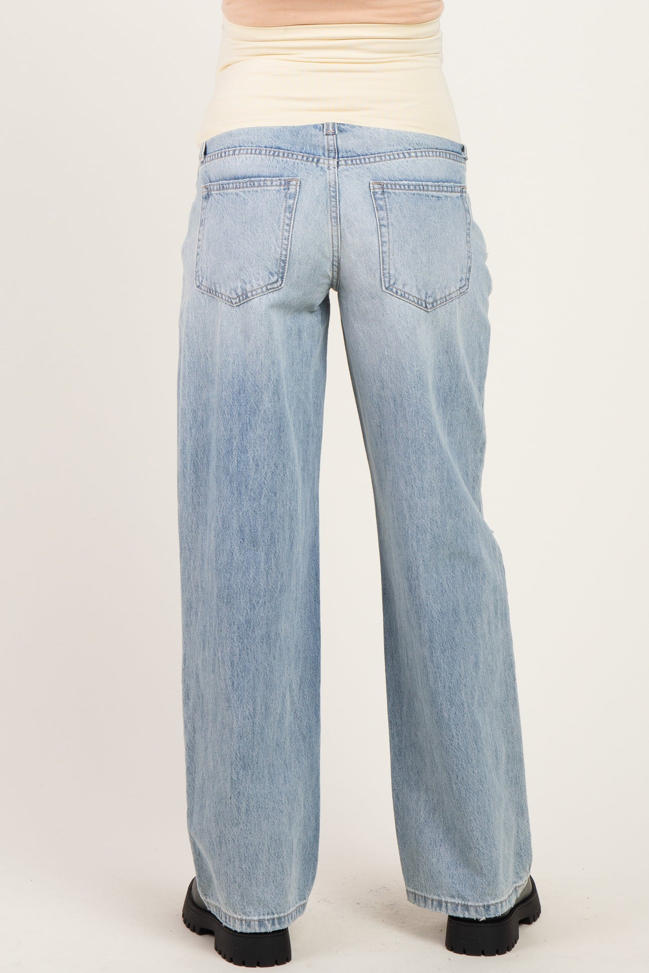 woman wearing light blue maternity wide-leg jeans, shown from the back, with a comfortable waistband