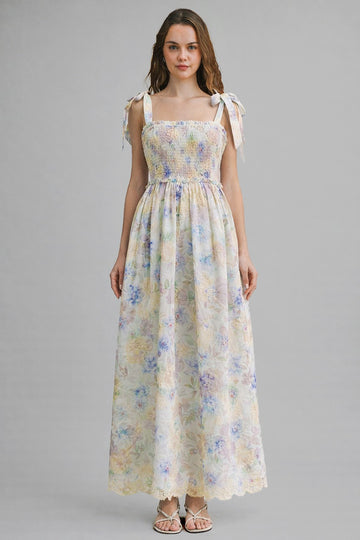 woman wearing a floral maxi dress with smocked bodice and tie shoulder straps