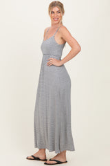 woman wearing a gray and white striped maxi dress with thin straps and a flowy fit