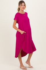 woman wearing a bright pink short sleeve maternity dress with pockets and asymmetric hemline