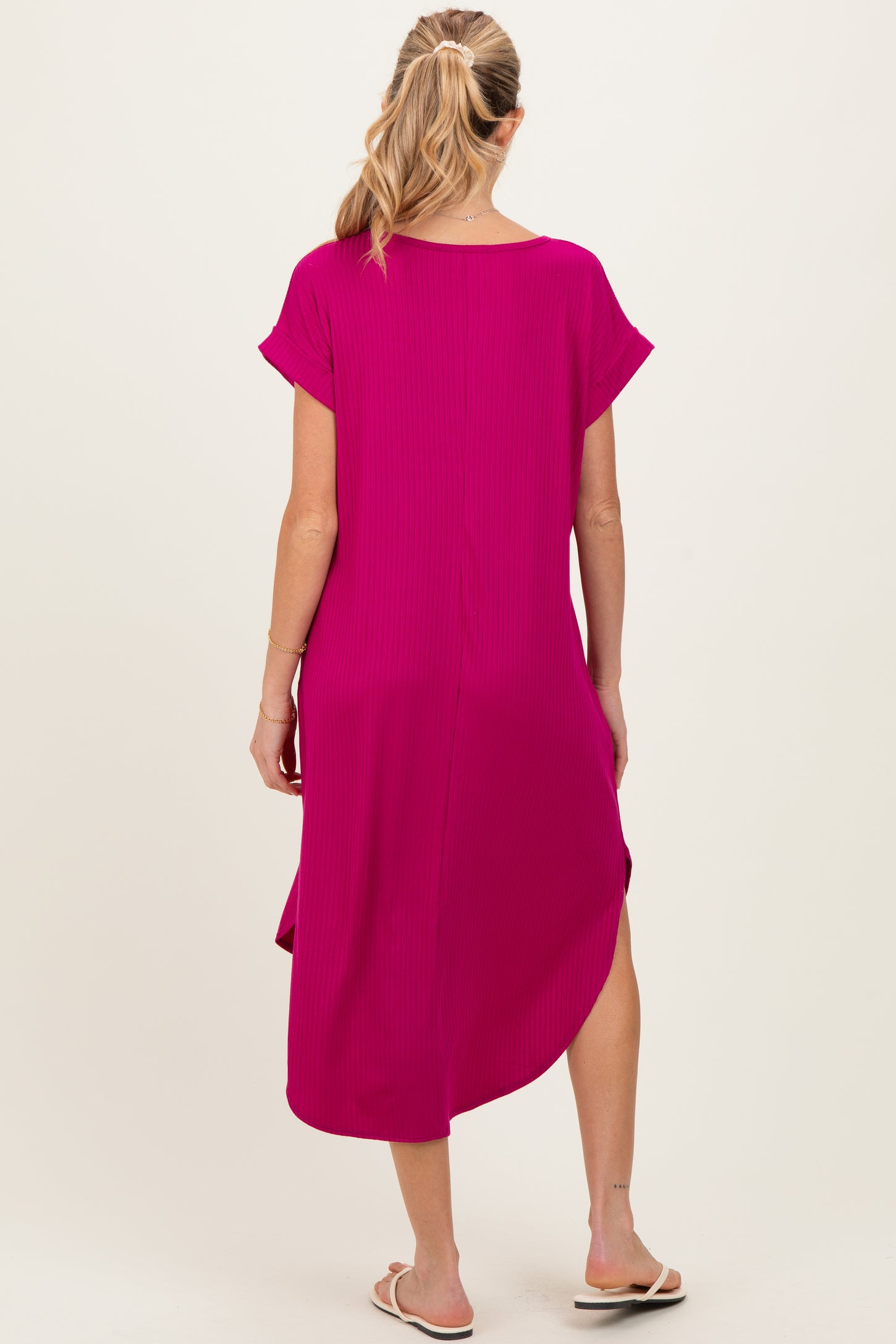 woman wearing a hot pink maternity midi dress with short sleeves and a slit on the side