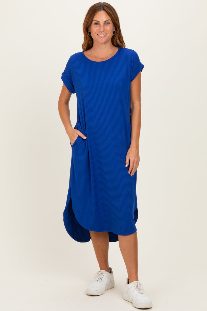 woman wearing a blue ribbed short sleeve midi dress with side pockets and a curved hemline