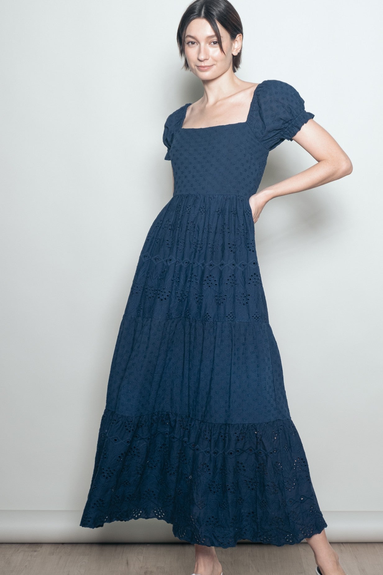 woman wearing a navy blue tiered maxi dress with puff sleeves and square neckline