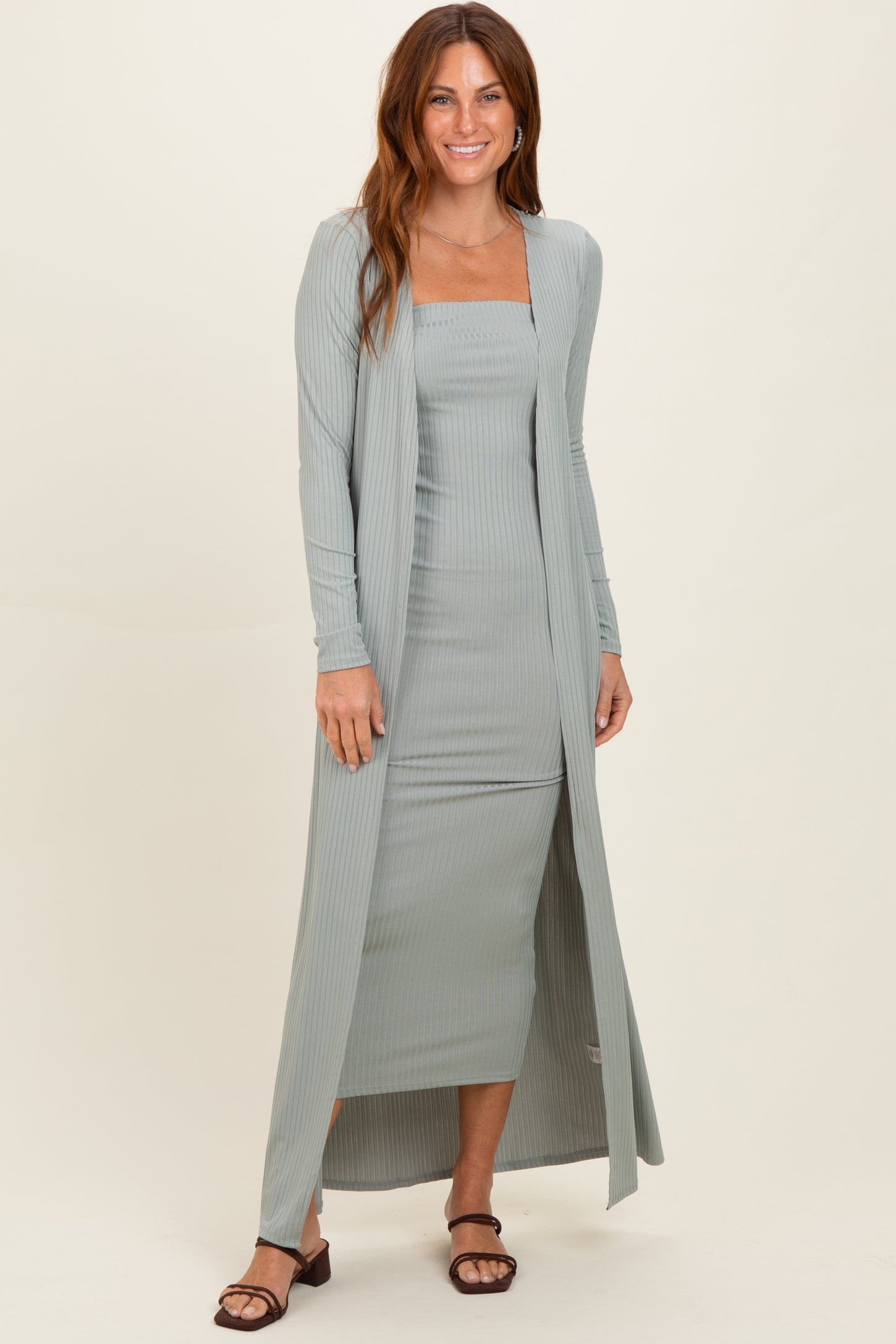 woman wearing a light green ribbed two-piece dress set with a long cardigan and fitted dress