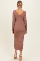 woman wearing a mauve long sleeve ribbed maternity dress with a v-back and a slim fit silhouette