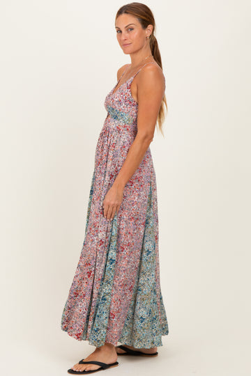 woman wearing a colorful floral maxi dress with a fitted bodice and flowy skirt, standing sideways