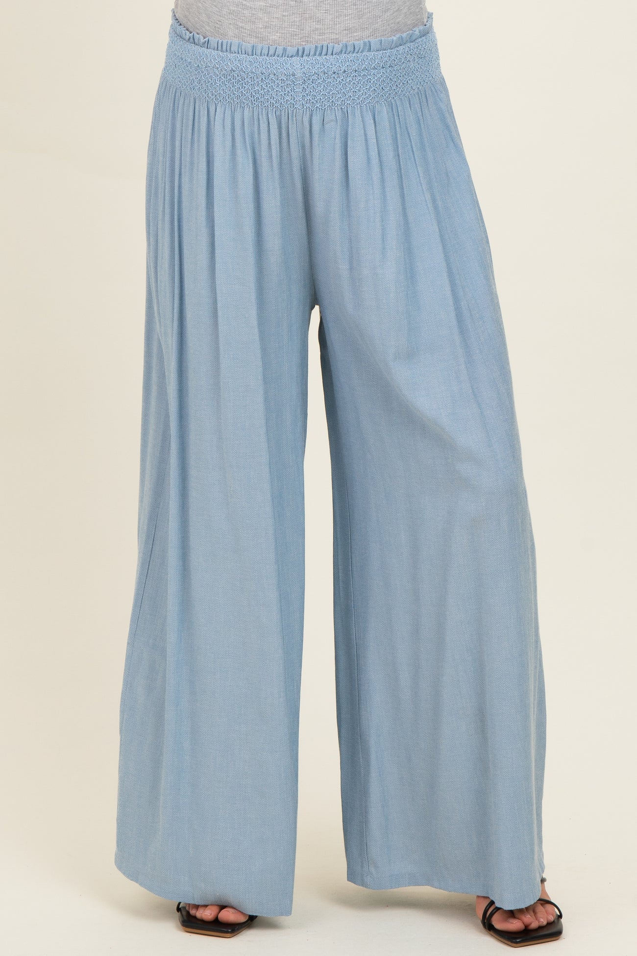 woman wearing light blue wide-leg maternity pants with a smocked waistband