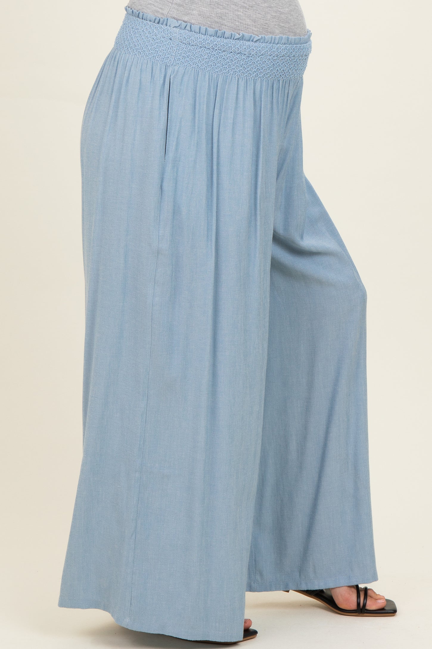 woman wearing light blue maternity wide-leg pants with a smocked waistband