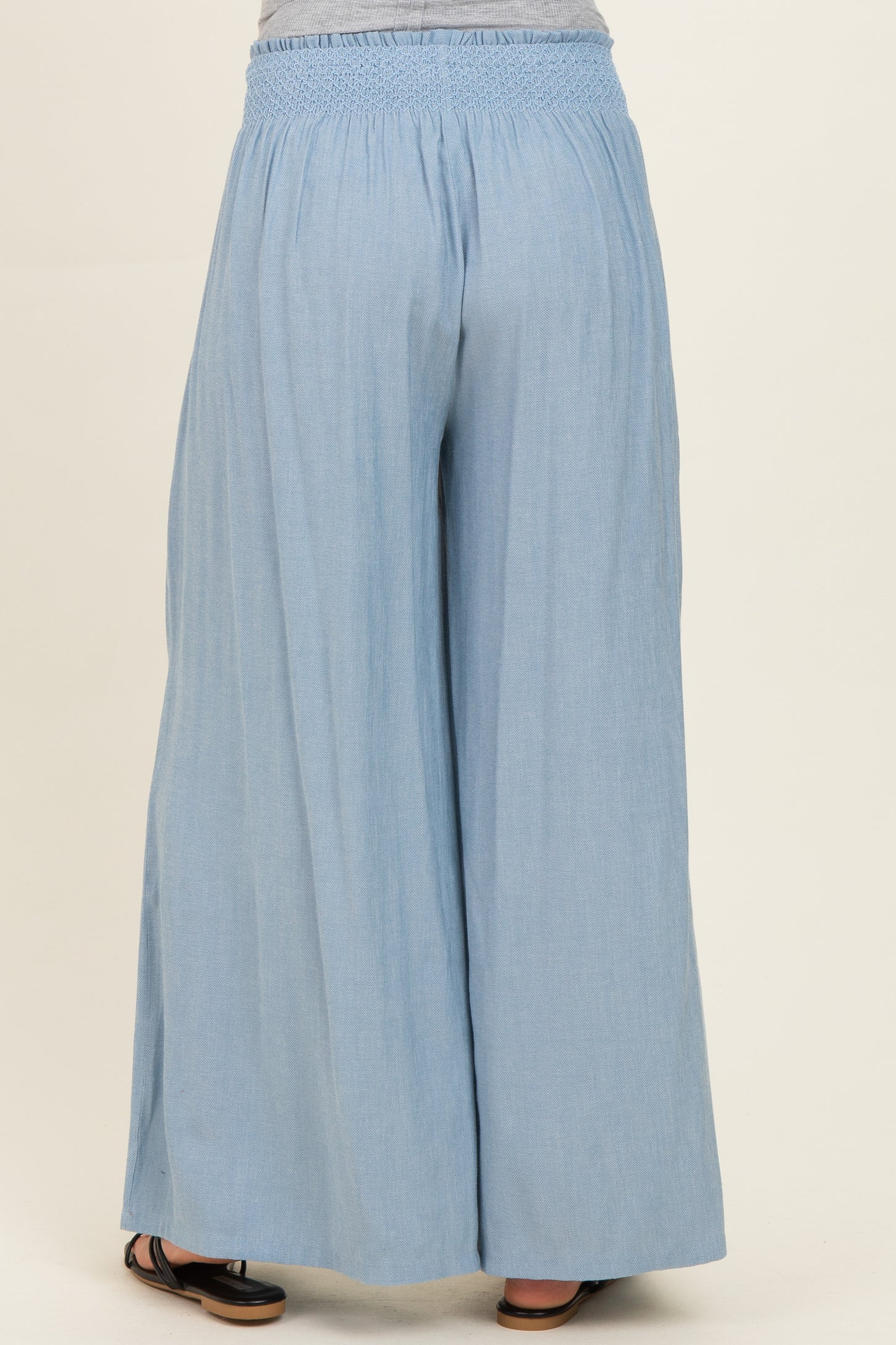 woman wearing light blue maternity wide-leg pants with an elastic waistband, viewed from the back
