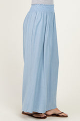 woman wearing light blue wide-leg pants with a smocked waistband and sandals