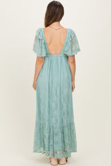 woman wearing a backless light blue lace maternity gown with flutter sleeves and a flowy skirt