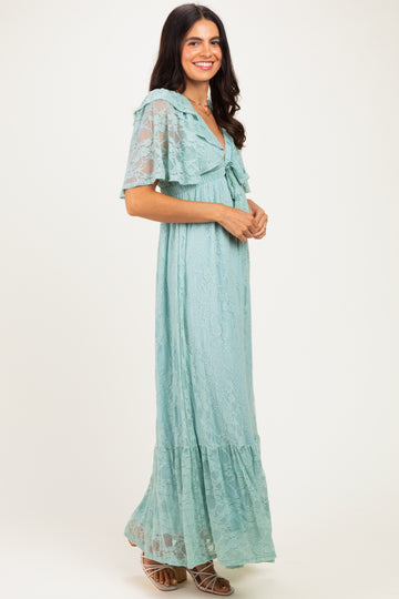 woman wearing a light teal lace maxi dress with flutter sleeves and a ruffle hem