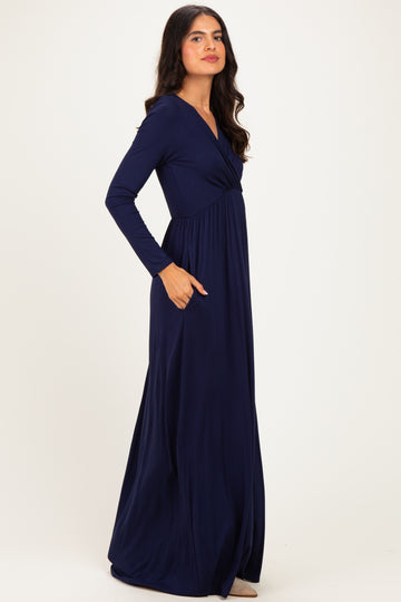 woman wearing a long sleeve navy blue maxi dress with a wrap design and side pockets
