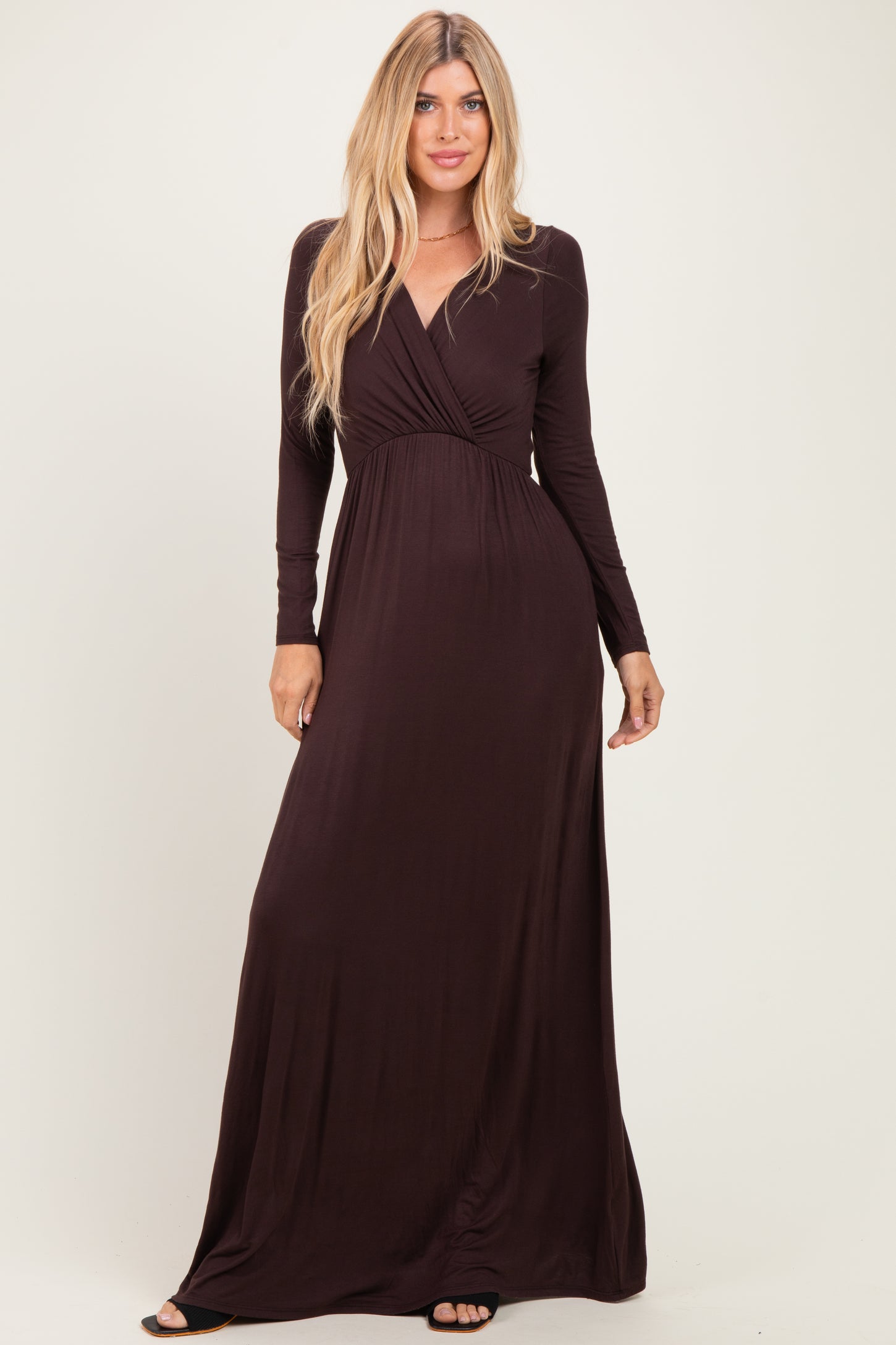 woman wearing a dark burgundy long sleeve maxi dress with a deep v-neck and wrap detail