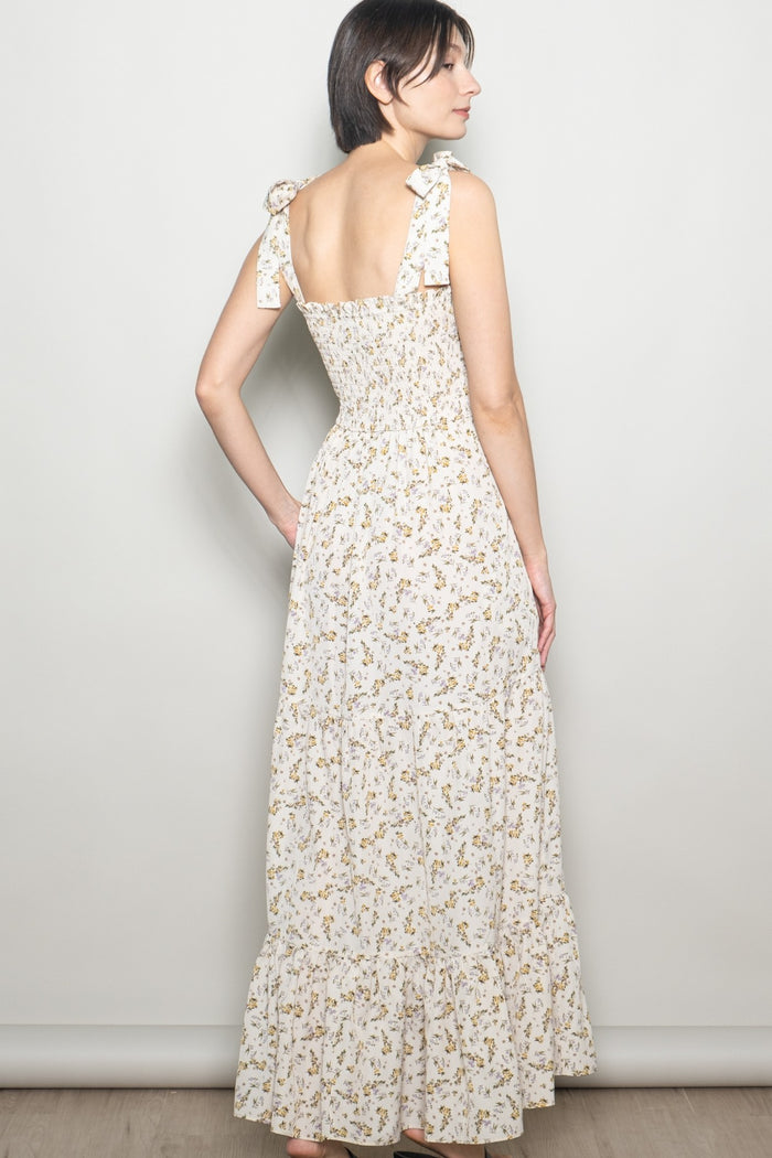 woman wearing a white floral maxi dress with ruffled straps and a smocked back