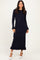 woman wearing a navy blue ribbed long sleeve maxi dress with ruffle hem and button details on sleeves