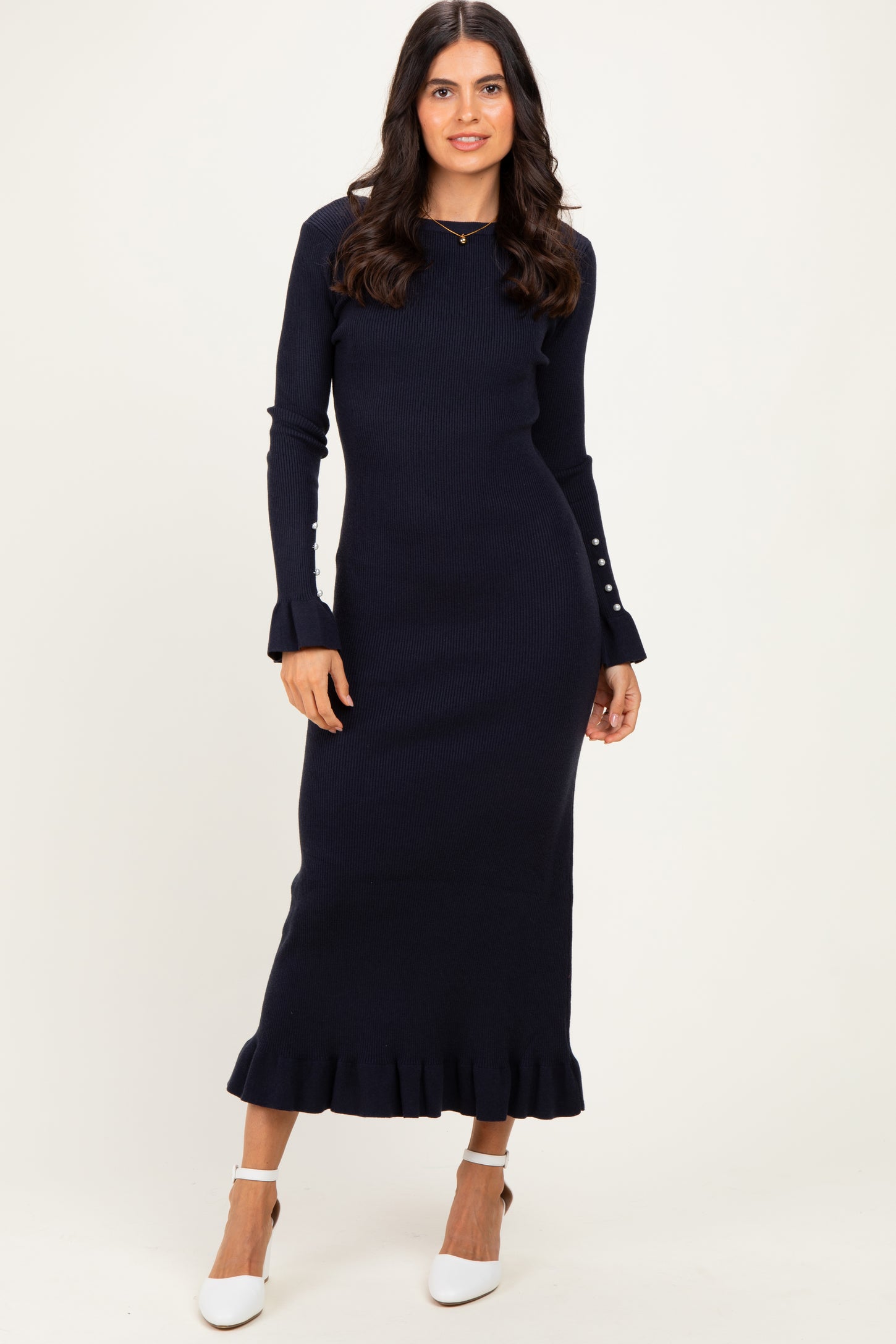 woman wearing a navy blue ribbed long sleeve maxi dress with ruffle hem and button details on sleeves