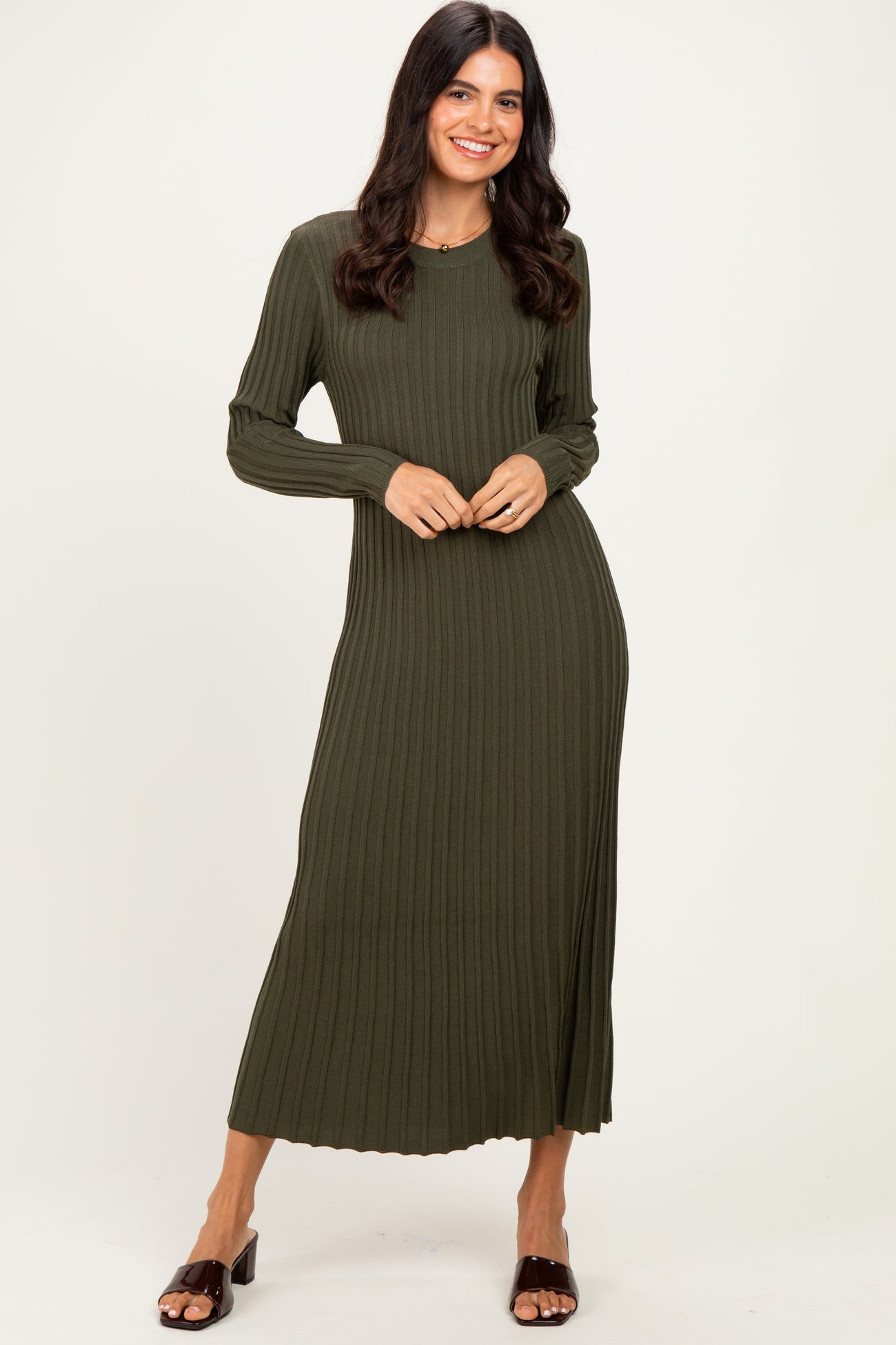woman wearing a dark olive green ribbed long sleeve maxi dress standing with hands on her waist