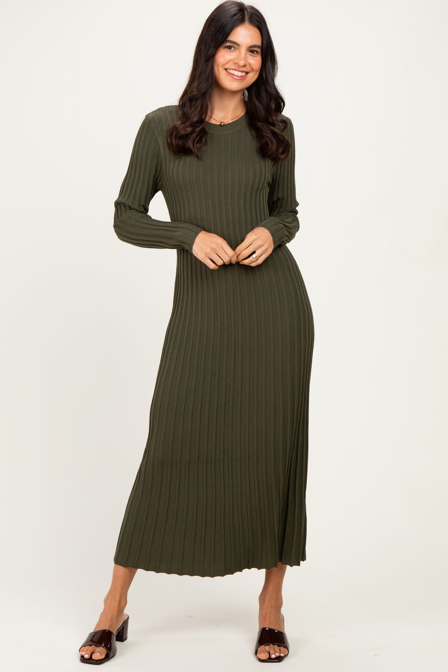 woman wearing a dark olive green ribbed long sleeve maxi dress standing with hands on her waist
