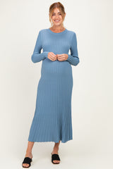 woman wearing a light blue ribbed maternity dress that flows to the mid-calf and showcasing her baby bump