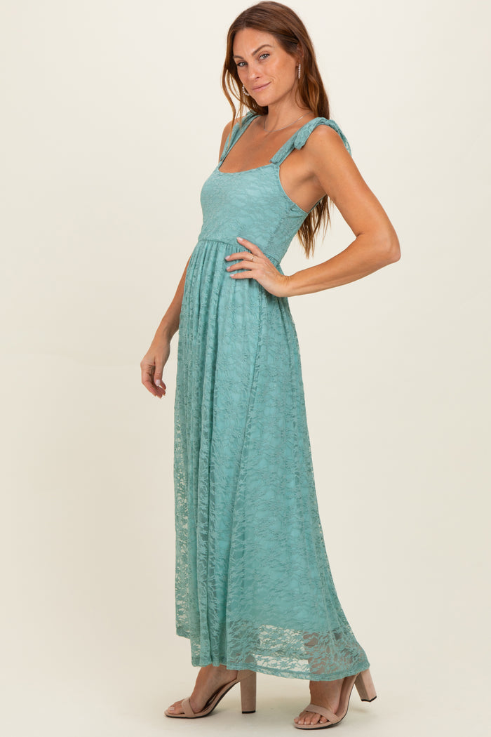 woman wearing a teal lace maxi dress with adjustable shoulder straps and a flowy skirt