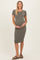 woman wearing a ribbed olive green maternity dress and holding her baby bump